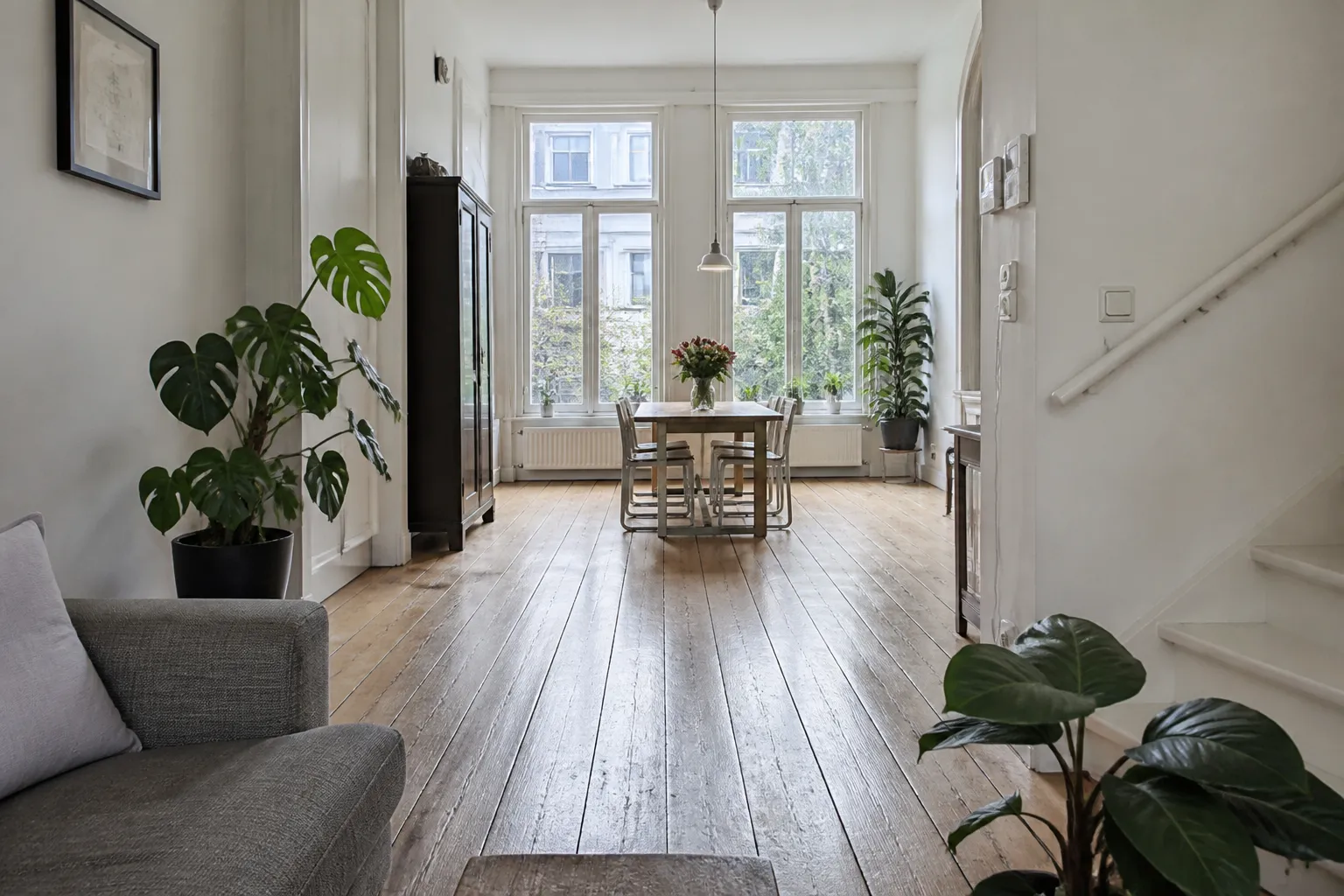 Eetkamer en woonkamer in een Amsterdams grachtenpand met een brede houten plankenvloer